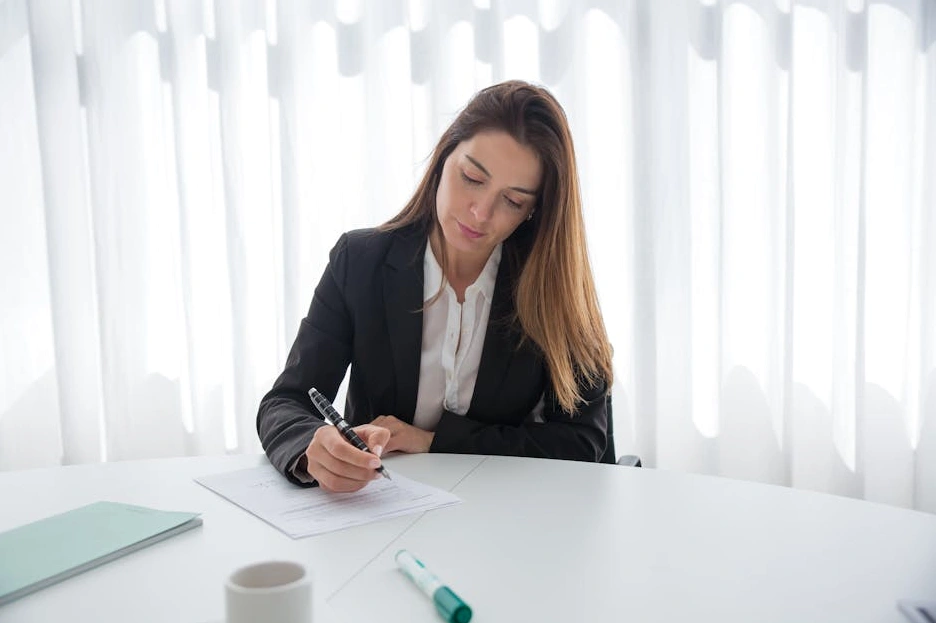 Elegancko ubrany menedżer podpisujący dokumenty w luksusowym biurze